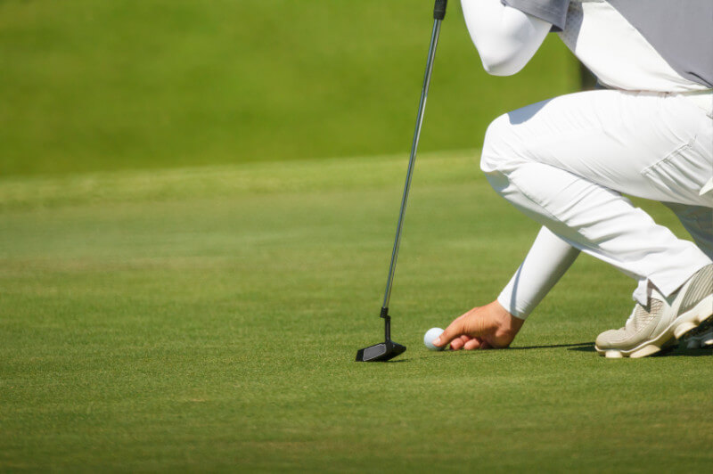 golfer marks his position on a green